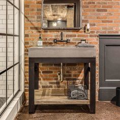 a bathroom with a brick wall and sink