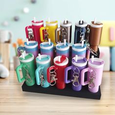 several different colored mugs with key chains attached to them