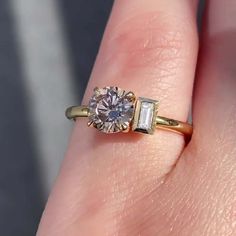 a woman's hand with a ring on it and a diamond in the middle