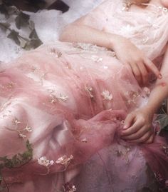 a woman in a pink dress is laying down