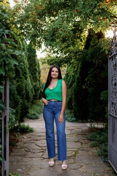 a woman is standing in the middle of a path with her hands on her hips