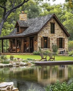 a house sitting next to a lake in the middle of a forest with trees and grass