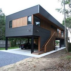 a car is parked in front of a modern house with stairs leading up to the second floor