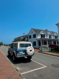 an old jeep is parked on the side of the road in front of some houses