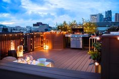 an outdoor deck with lights on it and a grill in the middle, surrounded by furniture