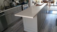 a kitchen with an island in the middle and stainless steel appliances on the other side