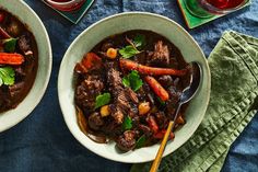 two bowls of beef stew with carrots and green garnish on the side