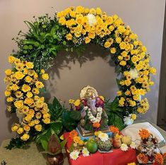 there is a shrine with yellow flowers on the table and an idol in the middle