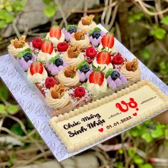 a cake decorated with fruit is being held by someone