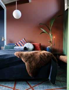 a bedroom with a blue bed and orange walls