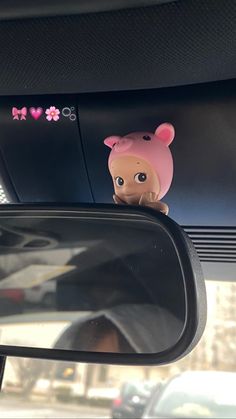 a car mirror with a little pig sticker on it