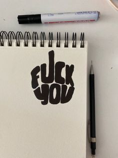 a notepad with the word fluck you written on it next to a pen