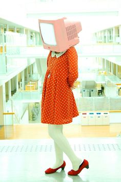 a woman with a pink computer on her head in a red dress and white socks