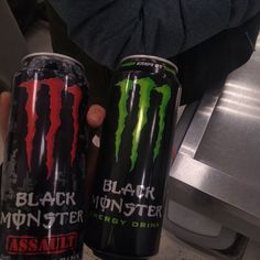 two cans of monster energy drink sitting next to each other