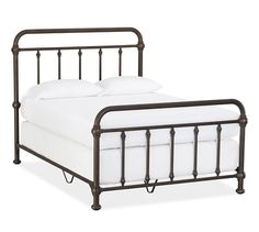 an iron bed frame with white linens and pillows on the bottom, against a white background