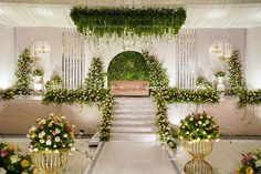 an indoor wedding venue decorated with flowers and greenery