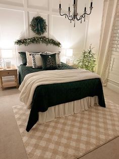 a bedroom with a bed, chandelier and christmas decorations on the wall above it