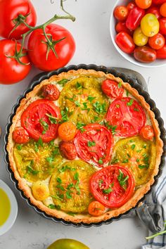 a pie with tomatoes and other vegetables on the table