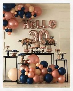 a table topped with balloons and cake next to a sign that says hello 30 on it