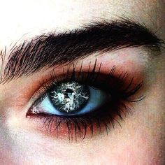 a close up of a person's blue eye with black and white glitter on it