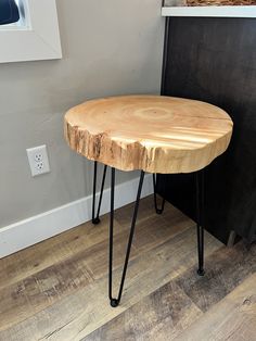 a wooden table with black hairpinks on it and a basket in the background