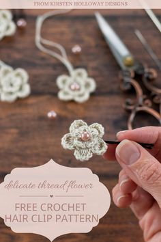 a person is holding a crochet flower in front of some scissors and other crafting supplies