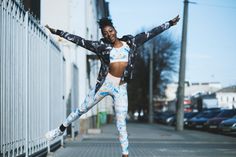 a woman is jumping in the air with her arms outstretched