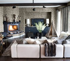 a living room filled with furniture and a fire place in the middle of it's wall