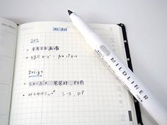 an open notebook with writing on it and a pen sitting next to it in the middle