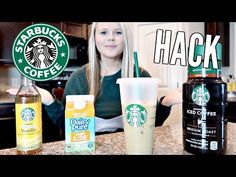 a woman sitting at a counter with starbucks drinks