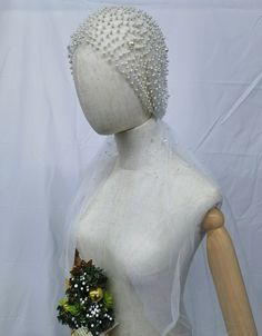 a white mannequin wearing a bridal dress with flowers on it's head