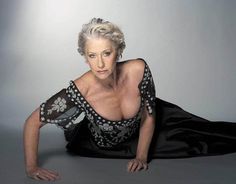 an older woman laying on the ground in a black dress with silver trimmings