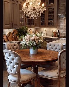 a dining room table with chairs and a chandelier hanging from the ceiling above it