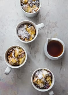 three mugs filled with food sitting on top of a table