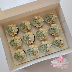 twelve cupcakes in a box decorated with flowers