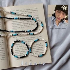 an open book with two necklaces on it next to a photo of a woman