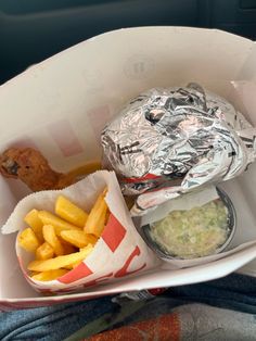 a person holding a tray with some food in it