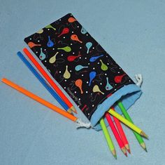 several colored pencils in a pouch on a blue surface