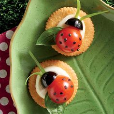 two small pastries with ladybugs on them sitting on a green platter