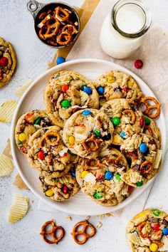 cookies and pretzels on a white plate next to a glass of milk