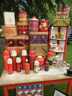 a table topped with lots of red and blue tin canisters next to each other