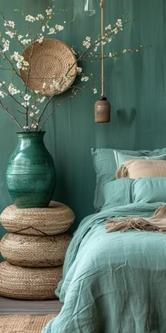 a bed room with a neatly made bed and vases filled with flowers on the headboard