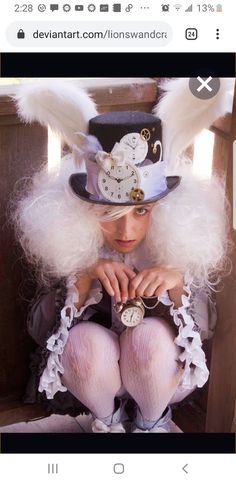 a woman with white hair and angel wings on her head is sitting in a chair