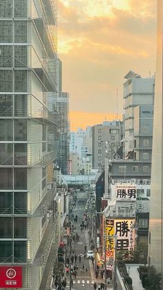 a city street filled with lots of tall buildings and people walking on the side walk