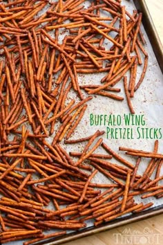 a baking sheet filled with buffalo wing pretzels