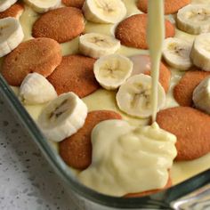 bananas and cream are being drizzled on top of the food in the dish