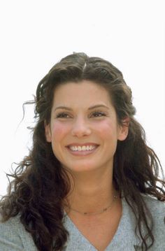 a woman with long hair smiling at the camera