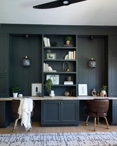 a kitchen with dark green cabinets and white counter tops, an area rug on the floor