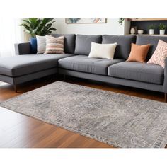 a large gray couch sitting on top of a wooden floor