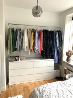 a bedroom with clothes hanging on the wall